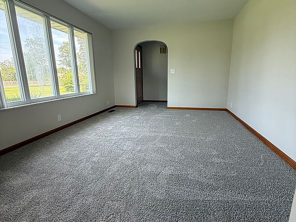 Living room with large windows overlooking the front yard.