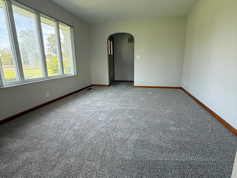 Living room with large windows overlooking the front yard.