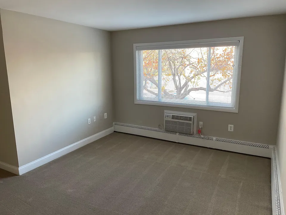 Living room with through-the-wall air conditioner unit.