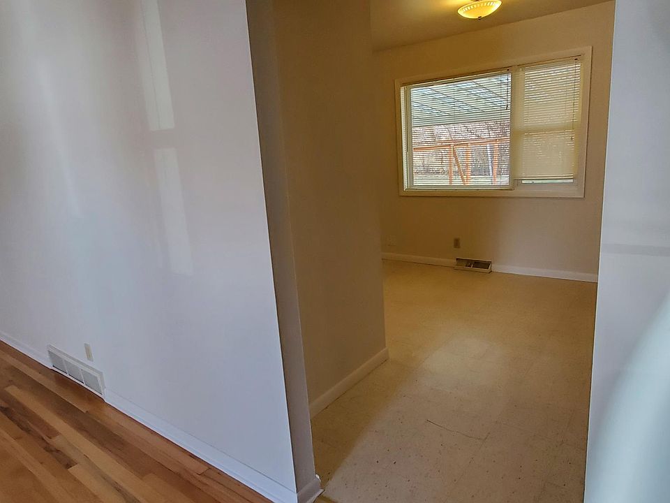 Looking from the living room/hallway into the dining room and attached kitchen. Window looks out on the back yard.