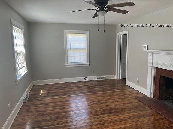 Formal living room with fireplace, original hardwoods and ceiling fan