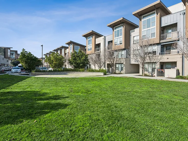 Aspire Apartments Tracy California Luxury Living Apartment complex with a fountain in the middle of a grassy area.