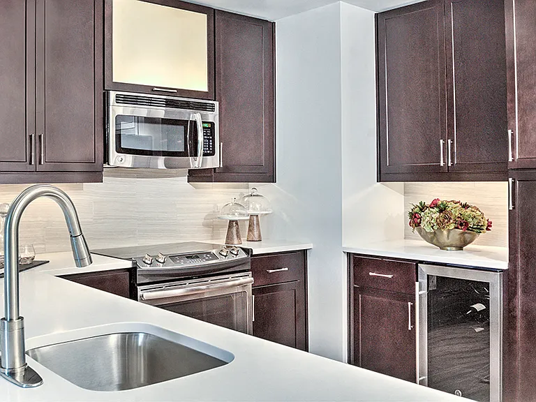 Walnut finish cabinets with under cabinet lighting and contemporary fixtures