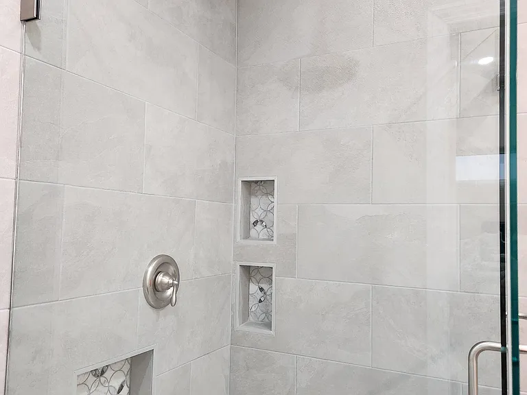 Rain shower -state of the art bathroom with built-in shelfs, tile, seashell tiles and all glass doors.