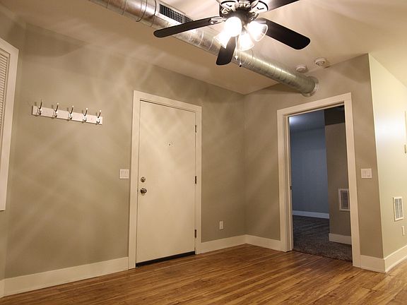 Another view of the living room, looking at the main entrance into the apartment and the bedroom.