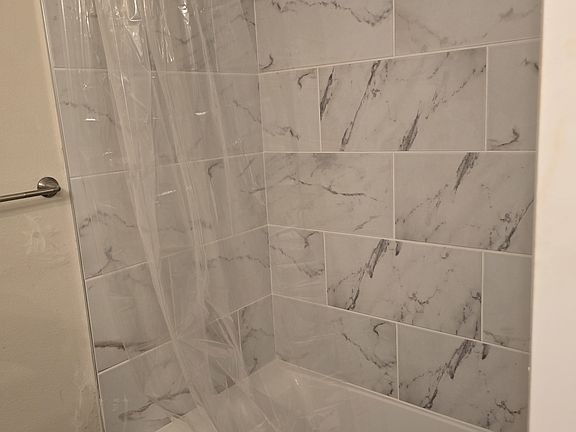 new tub / shower with tile to ceiling.