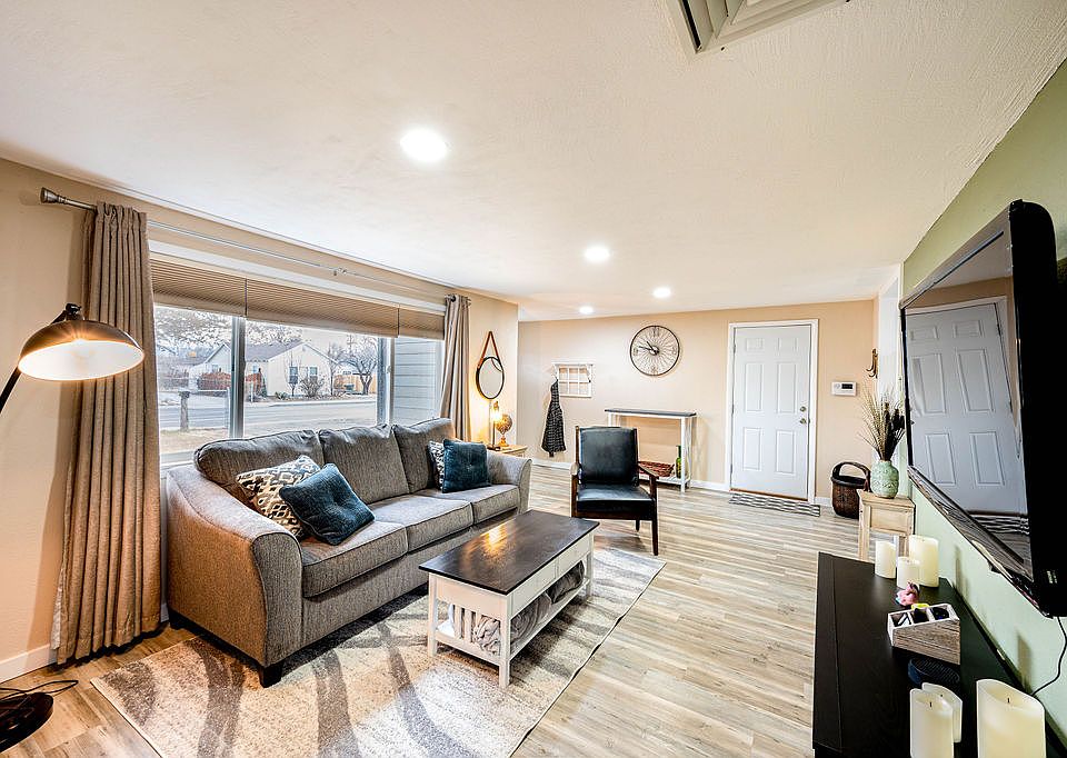 Large family room with couch, chair, and wall-mounted TV