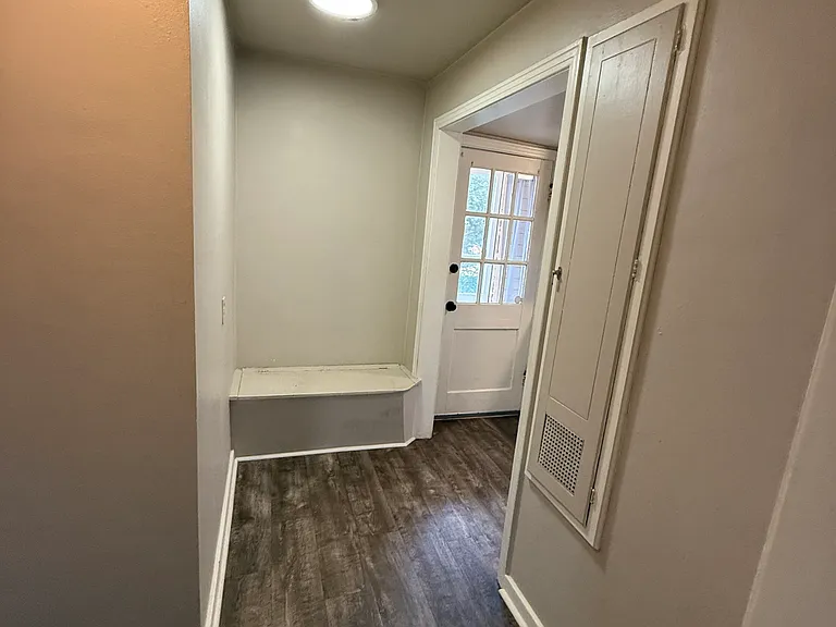 Hall between living room, bathroom, and kitchen. Note storage under bench seat.
