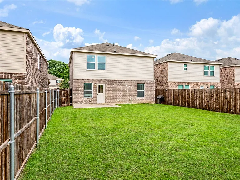 Expansive green lawn with a full wooden privacy fence