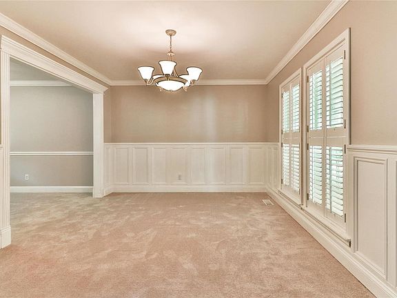 Living room has fresh paint, new carpeting, plantation shutters, and beautiful woodwork.