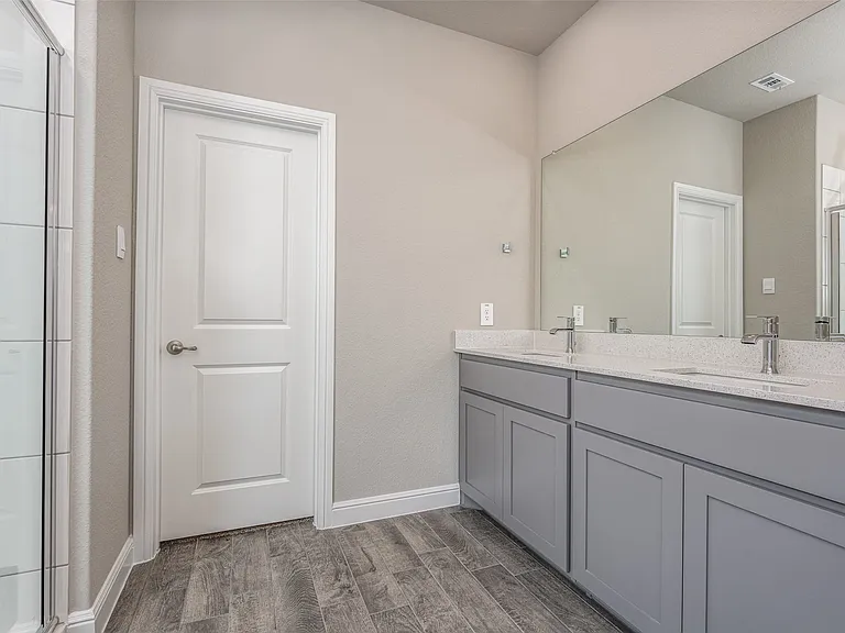 Bathroom featuring dual sinks, an enclosed shower, hardwood / wood-style flooring, and large vanity