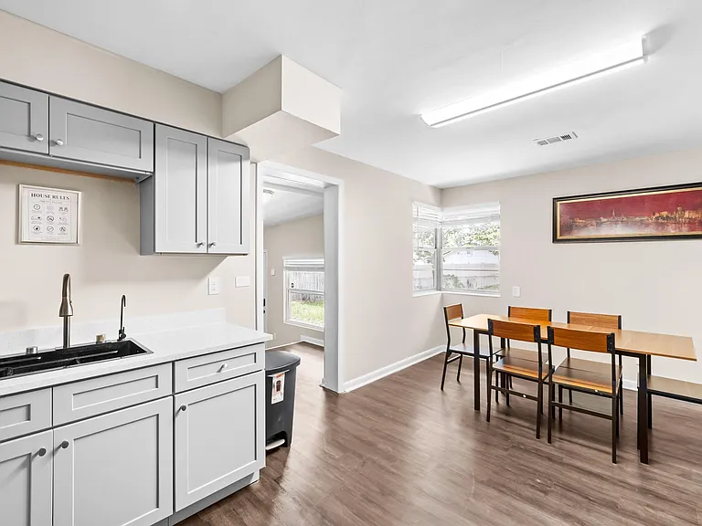 Eat-in kitchen area with ample cabinetry, prep space, and a dining table set beside a multi-window nook.