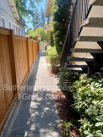 Foot path view toward back pedestrian gate to resident parking carport and garage