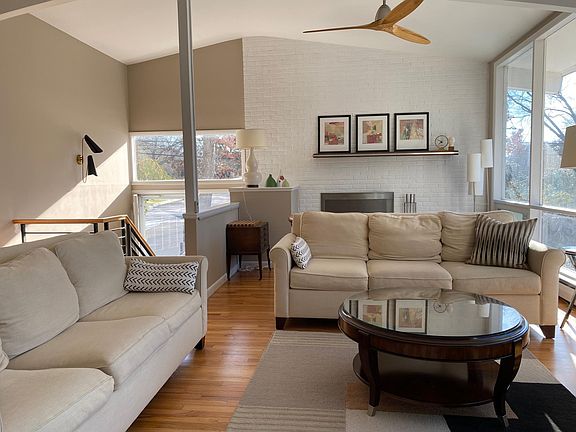 View of Living room from the TV. Fire place is on the back wall and has two cozy leather club chairs.