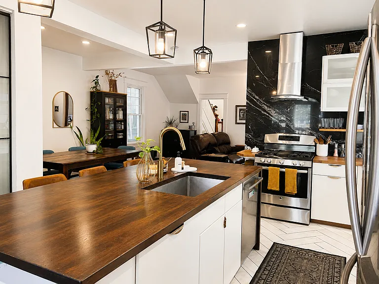 Gourmet kitchen with black granite backsplash, stainless steel appliances, butcher block counter tops and custom 8-foot wooden waterfall island