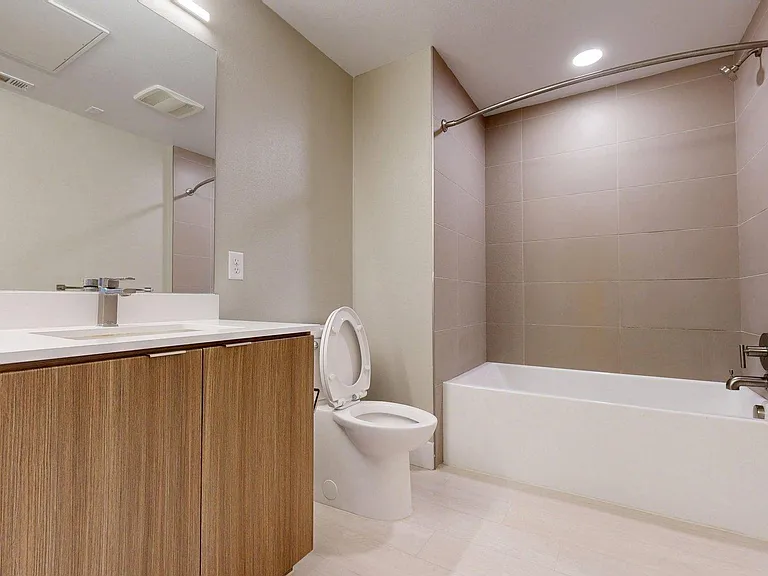 Apartment Bathroom with large soaking tub,vanity mirror and Wood-Style Flooring.