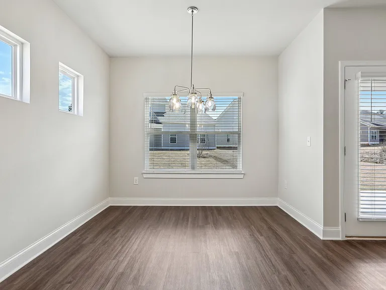 Bright room with wood floors and a large window, perfect for a kitchen table.