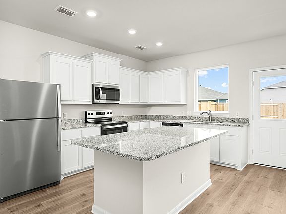 The kitchen has beautiful white wood cabinetry.