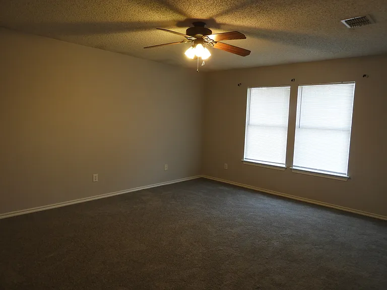 Primary Bedroom with ceiling fan and walk-in closet.