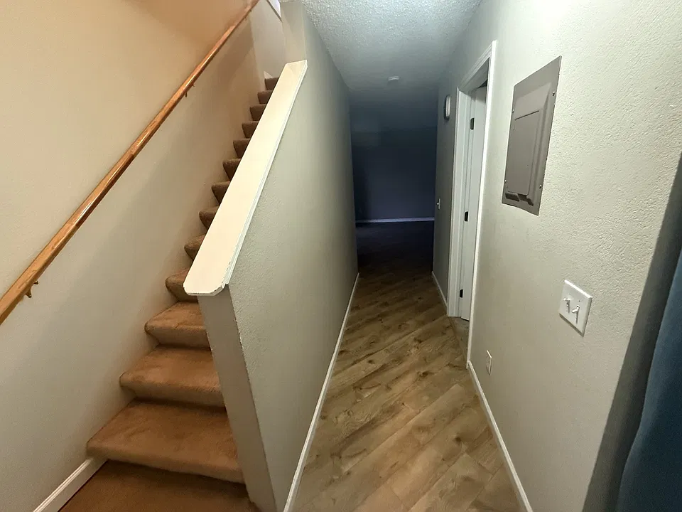 Hallway to downstairs living area and staircase to second floor.