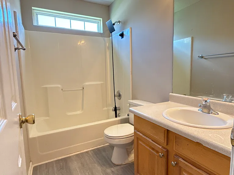Full second bathroom featuring a spacious vanity with cabinet storage and a clean tub/shower combination.