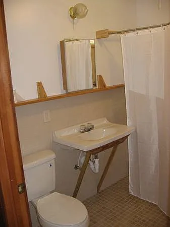 shower in tiled bathroom is not in view, no tub