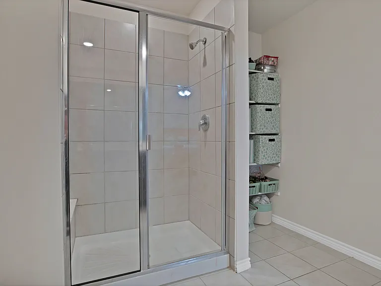 Master bath featuring an oversized shower with extra storage shelves