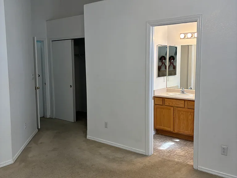Master bedroom showing entrance to master bathroom and one of two closets in this room.