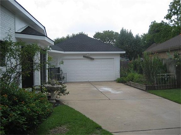 Two car garage with ample parking. Garden area to the right and storage behind and on the side of th