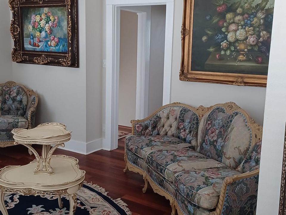 VIEW OF LIVING ROOM GORGEIOUS ANTIQUE LIVING ROOM SUITE, OIL PAITINGS, 12 FOOT CEILINGS, DECORATIVE WHITE MARBLE FIREPLACE