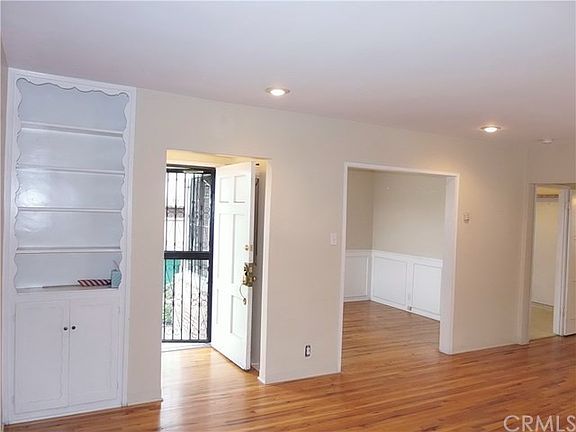 Standing in the Living Room you see built in shelves, front entry, Formal Dining Room with wainscot, next door way is kitchen.  Dining Room has doorway to kitchen as well.