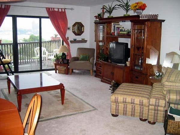 View of living room out to private deck