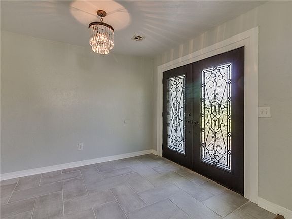 Gorgeous front entry door, tile floor and chandelier.