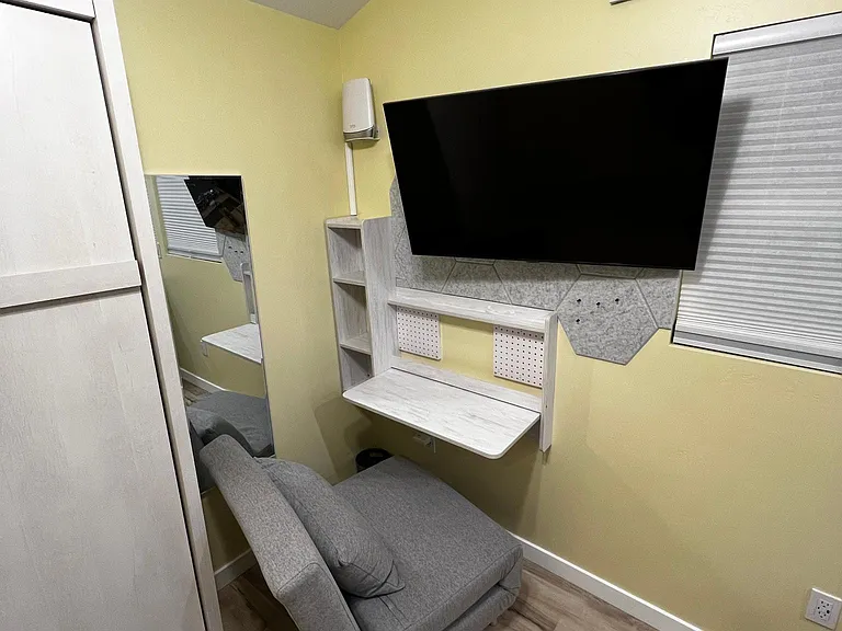 Dedicated workspace; TV, router, collapsible desk shown
