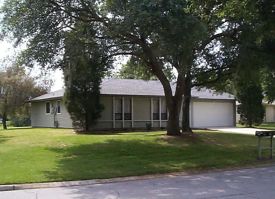 Mature oaks in front.