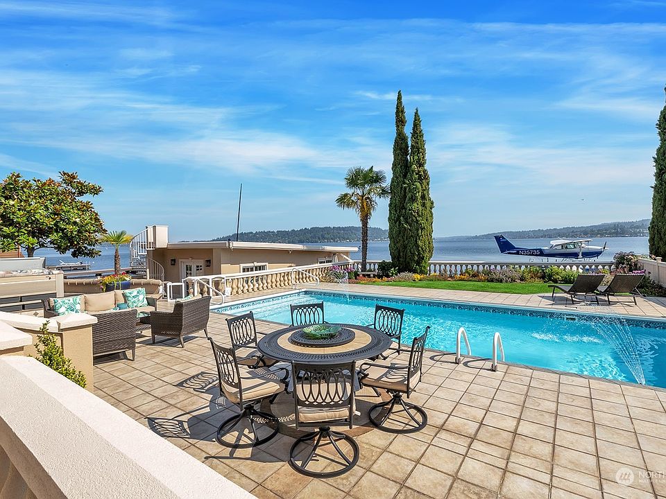 Lakefront with an in-ground pool and hot tub. Boat house with spiral staircase leading to the helipad.>