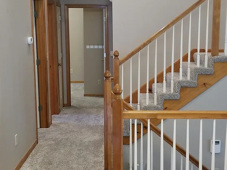 Kitchen view (portrait) to hallway that leads to two bedrooms and the master bedroom (upper right).