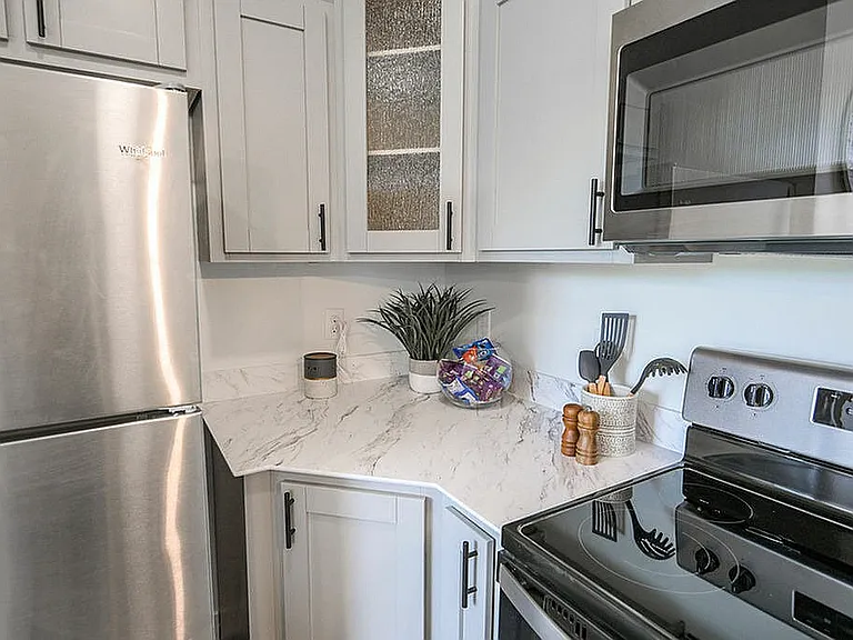 Modern kitchen with stainless steel appliances, elegant marble countertops, and sleek cabinetry.