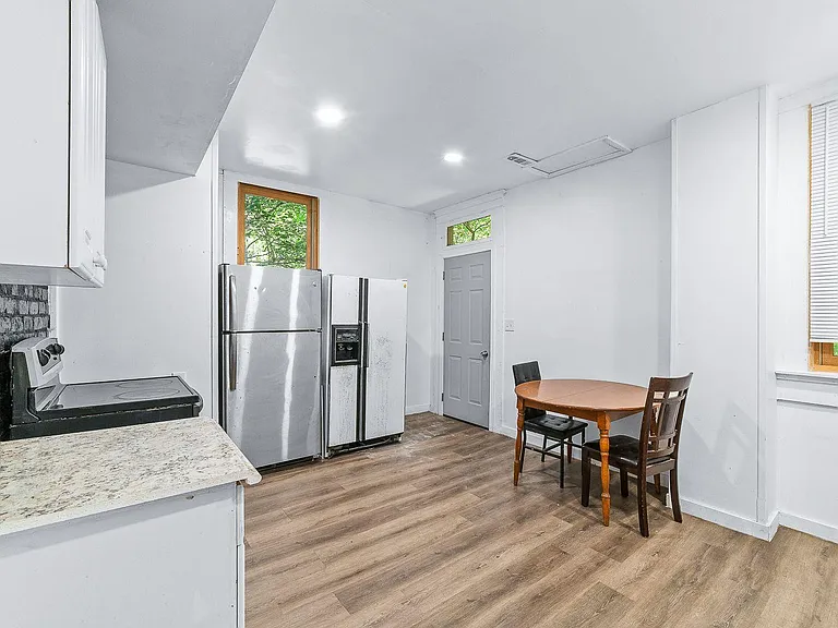 Open kitchen area with ample counter space, full-size refrigerator, and an eat-in table near windows for everyday meals.