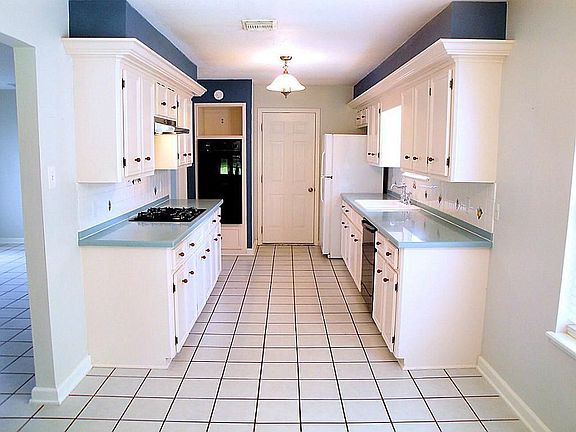 A view of the gourmet kitchen that features tile floors, lots of counter and cabinet space, corian c