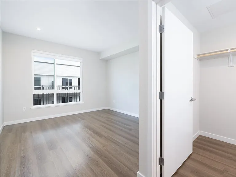 Upgrade Collection Primary bedroom and walk-in closet with hard-surface vinyl plank flooring