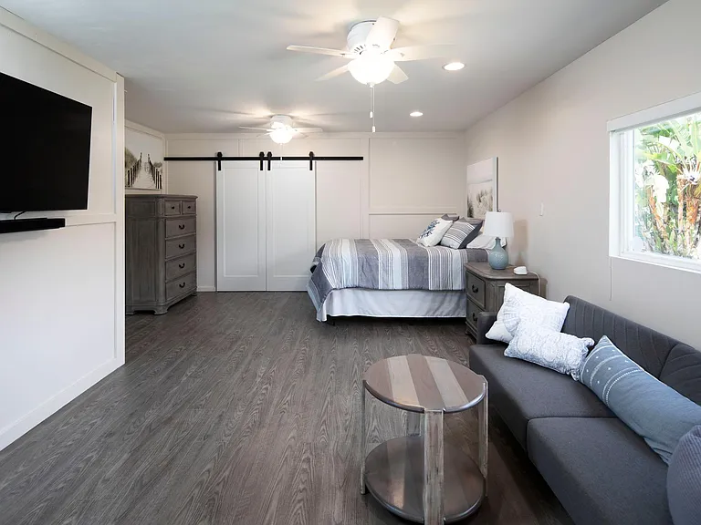 Downstairs with queen size bed, futon couch, TV and a built-in desk. This room provides privacy and separate living area for extra guests,