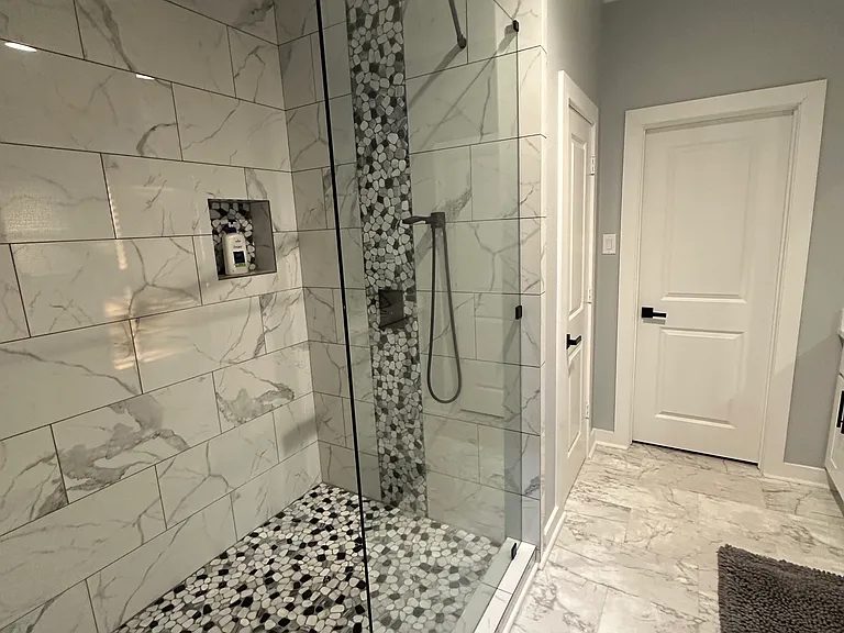 Large master bathroom walk in shower with rain head and hand held sprayer.