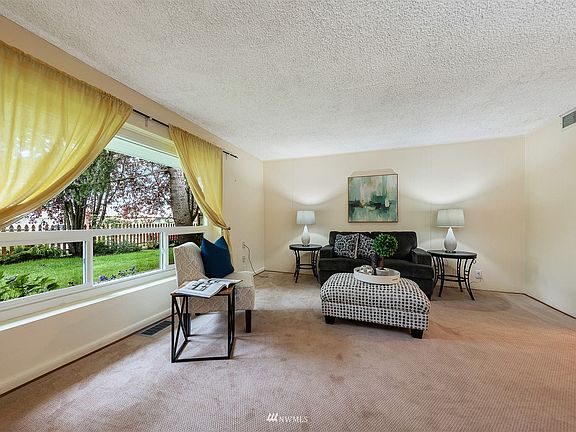 Oversized western-facing picture window overlooks the picket-fenced front yard. Seller liked privacy, but trim a couple branches and you have some sweet views of the Olympics!