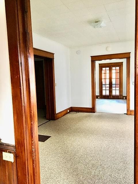 View of 2 common area rooms and French doors to sunporch from kitchen