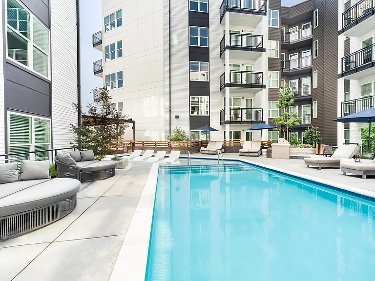 Pool courtyard with in-water loungers, shaded seating, and a relaxed outdoor setting that offers a refreshing retreat in Atlanta's Westside neighborhood.