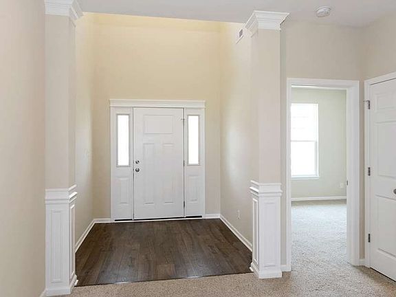 Volume foyer is beautifully trimmed out with columns and custom trim work.