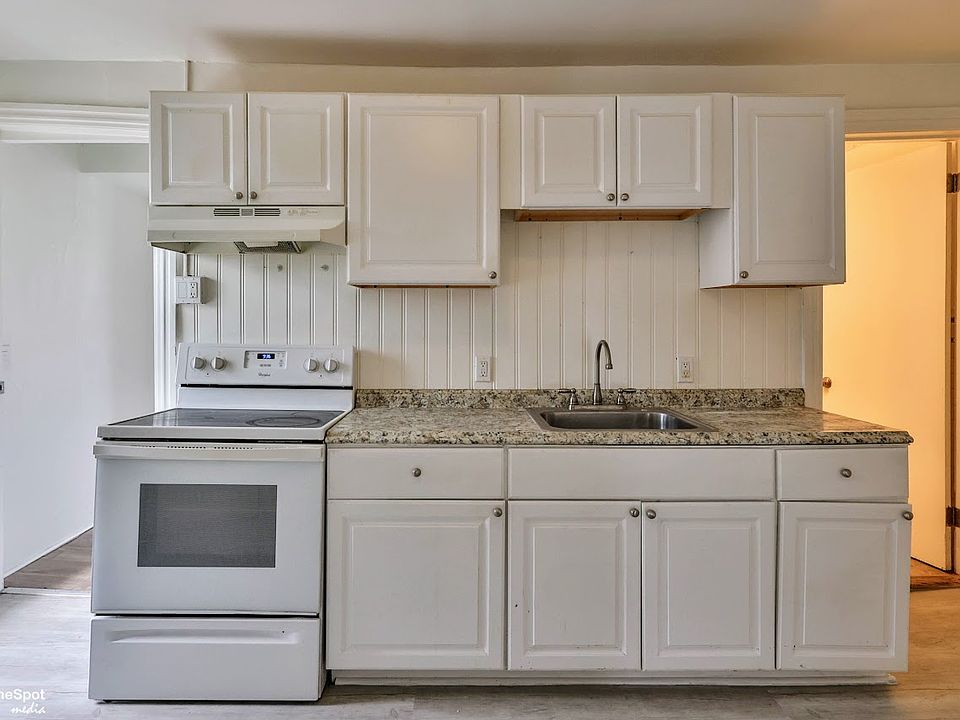 Kitchen w/ hallway to rear bedroom on left; bathroom on right