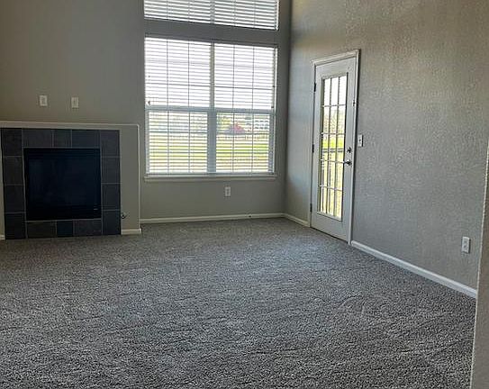 2 Story Living Room with gas fireplace and door to balcony with golf course view