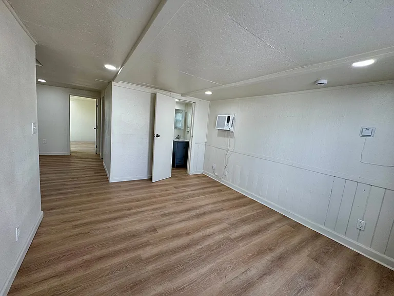 View from living room into dining room, secondary bedroom and bathroom.